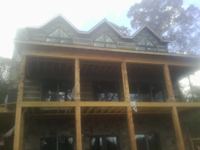 Dormers and porch framing on a large log home under construction — Roof Coating work by our crew in Greencastle